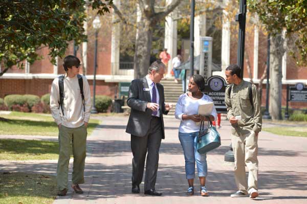 President Blake walking around campus talking with students.