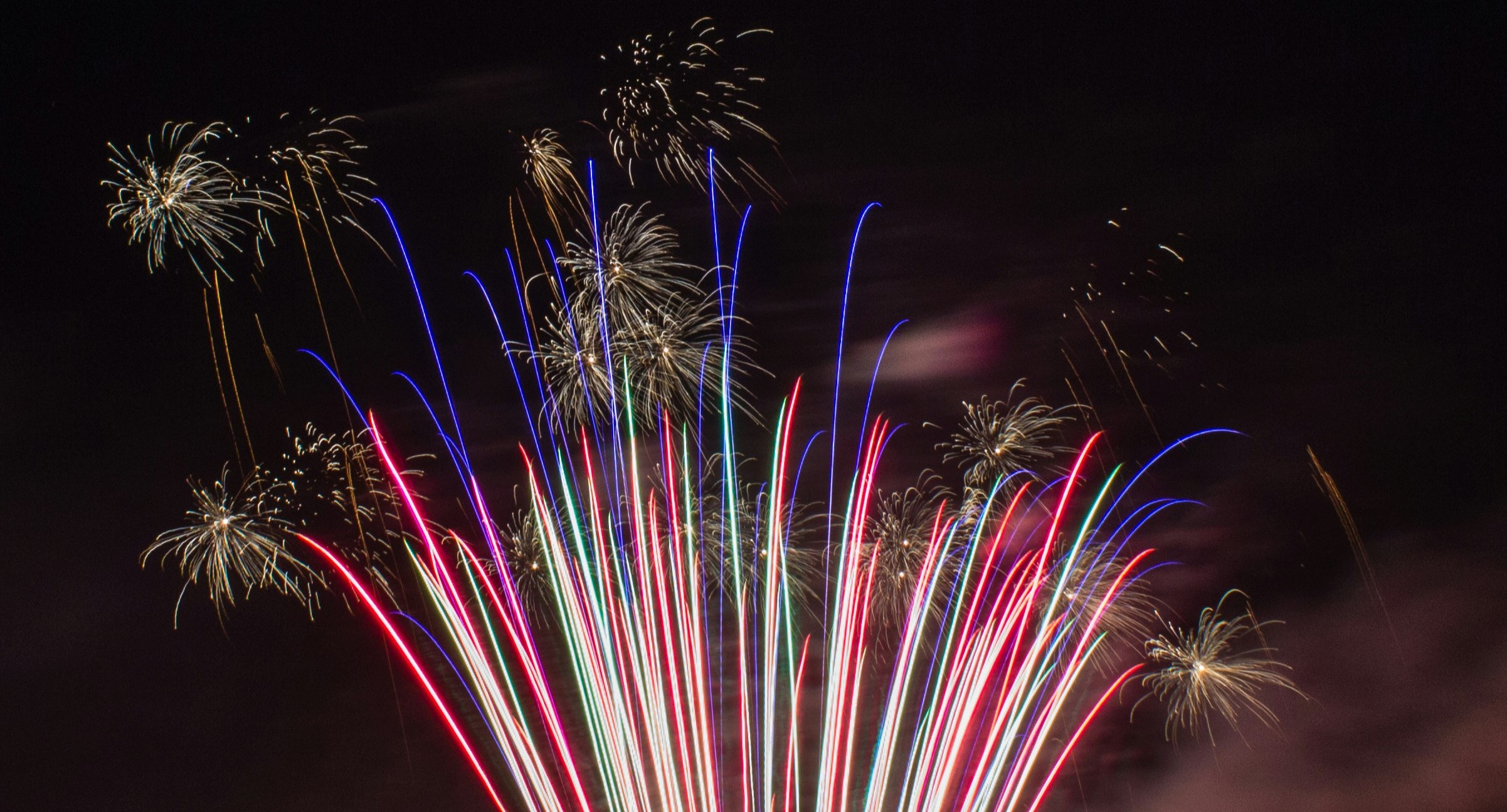 Red, white and blue fireworks exploding in the sky.